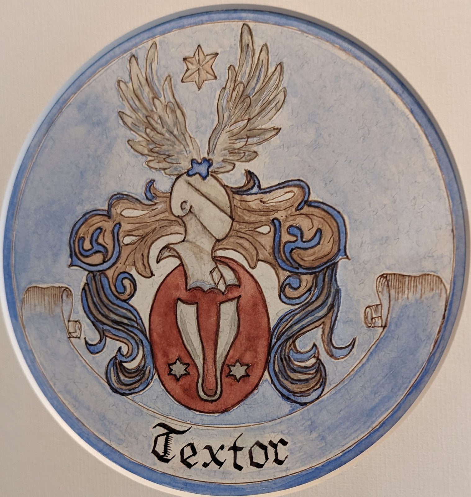 Wappen der Familie Textor — geflügelter Helm über rotem Schild mit Weberschiffchen und zwei sechsstrahligen Sternen, darunter der Schriftzug Textor